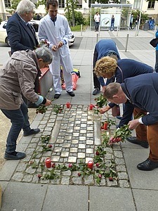 DGU verlegt Stolpersteine Mai 2023 © J. Arndt / DGU Menschen legen Blumen um Stolpersteine