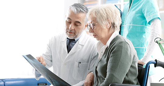 © StockPhotoPro / stock.adobe.com Arzt erklärt älterer Patientin Röntgenbild