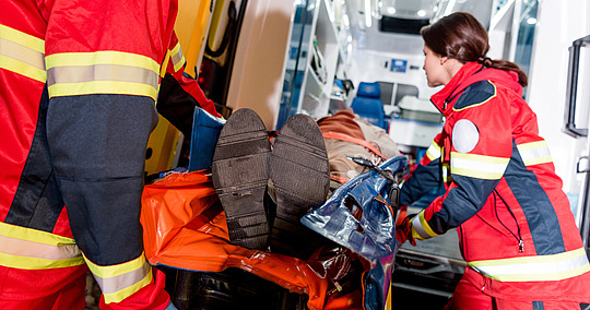 Rettungssanitäter laden Patienten in den Rettungswagen
