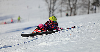 Kind ist beim Skifahren auf der Skipiste gestürzt