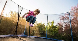 Kind springt auf Trampolin