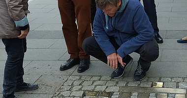 DGU verlegt Stolpersteine Mai 2023 © J. Arndt / DGU Mann begutachtet eingelassene Stolpersteine