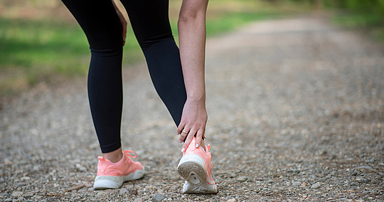 Läuferin hat Schmerzen in Achillessehne