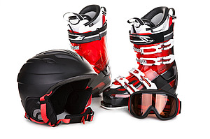 Skiausrüstung: rote Skistiefel, schwarzer Helm, Skibrille