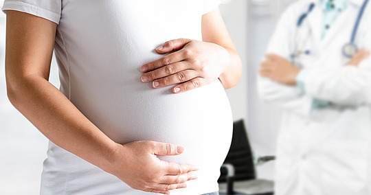 Schwangere umfasst ihren Bauch