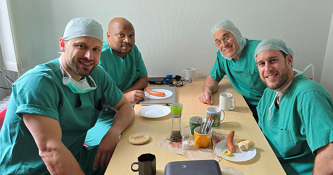Dr. Neill Blair (vorne rechts) und Dr. Sonke Khanyile (hinten links) zu Gast an der Universitätsmedizin Rostock © C. Lutter OP-Ärzte nehmen einen Imbiss ein